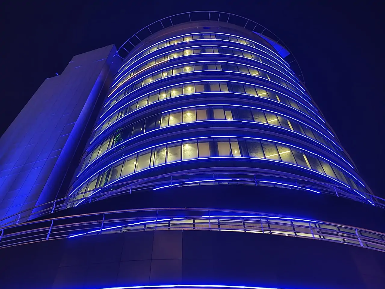 Decorative blue facade lighting on a Bahrain tower installed via rope access